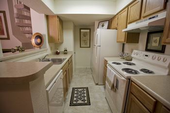 a kitchen with white appliances and wooden cabinets